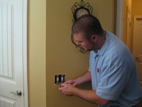 an electrician repairing a light switch 